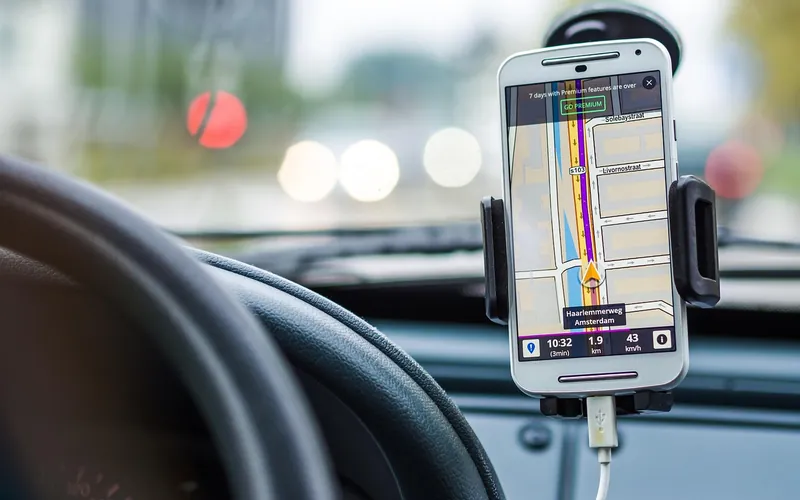 Vue conducteur avec smartphone GPS fixé au tableau de bord, trafic urbain