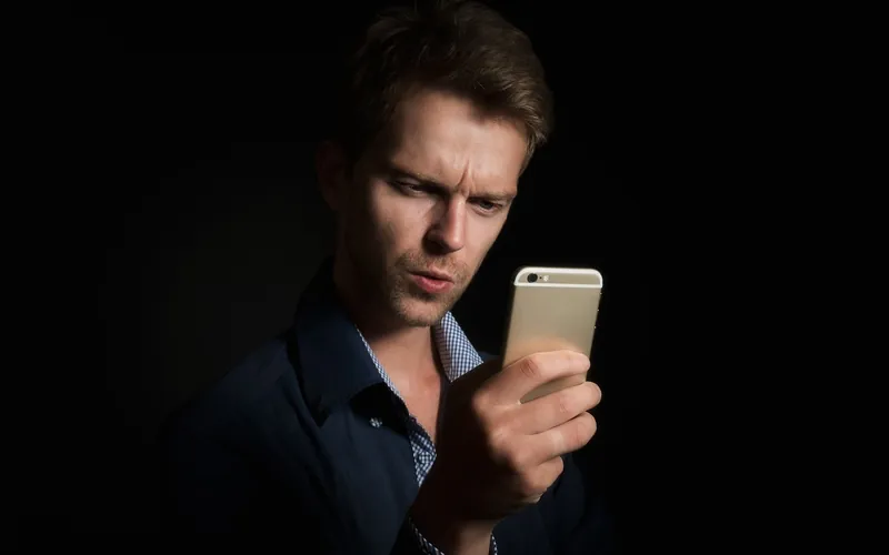Écran d'ordinateur affichant deux logiciels de comptabilité côte à côte, gestionnaire VTC consultant des tableaux de bord avec données Uber, bureau avec documents et téléphone